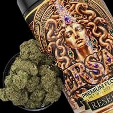Medusa Reserve Batch 28g jar showing ornate gold Medusa artwork next to a bowl of dense frosty green cannabis nugs